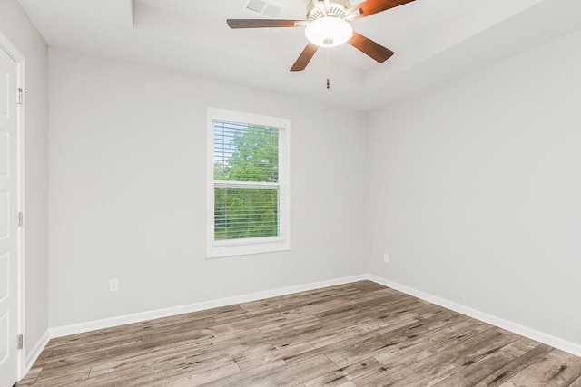 7515 Locust Dr, Kansas City, MO 64152 - spare room with wood finished floors, a tray ceiling, baseboards, and a ceiling fan