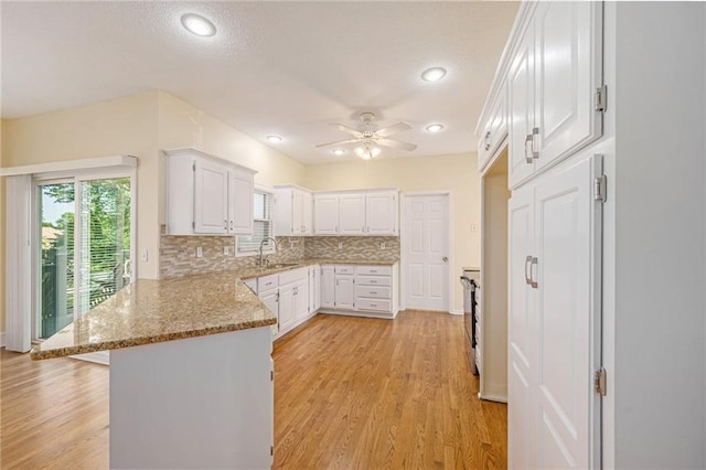 8901 W 128th St, Overland Park, KS 66213 - kitchen featuring a peninsula, a sink, white cabinets, a ceiling fan, and backsplash