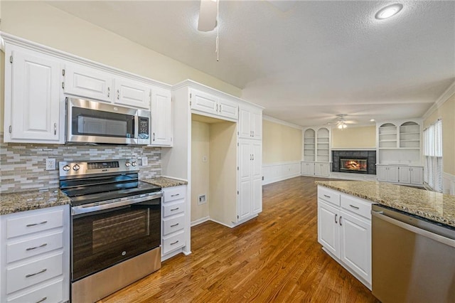 8901 W 128th St, Overland Park, KS 66213 - kitchen featuring stainless steel appliances, ceiling fan, light stone countertops, white cabinets, and wood finished floors