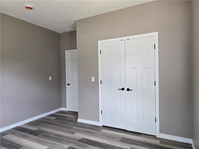 1101 Lakewood Dr, Pittsburg, KS 66762 - unfurnished bedroom featuring wood finished floors, a closet, and baseboards