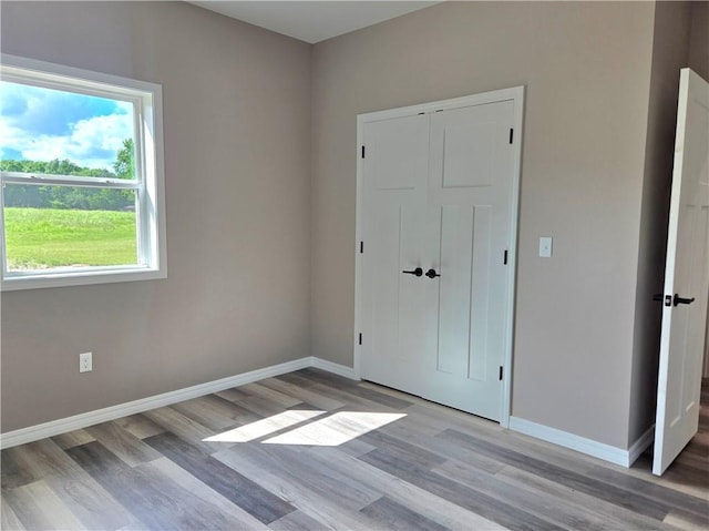 1101 Lakewood Dr, Pittsburg, KS 66762 - unfurnished bedroom with light wood-style floors, baseboards, and a closet