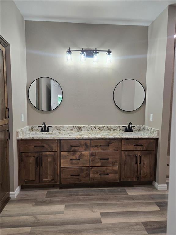1101 Lakewood Dr, Pittsburg, KS 66762 - full bathroom featuring double vanity, wood finished floors, and baseboards