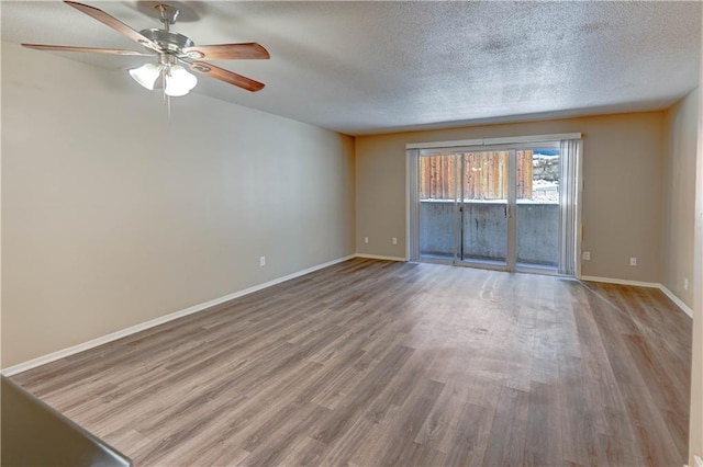 4157 Roanoke Rd Unit 2, Kansas City, MO 64111 - spare room featuring wood finished floors, ceiling fan, baseboards, and a textured ceiling