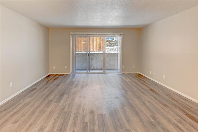 4157 Roanoke Rd Unit 2, Kansas City, MO 64111 - empty room featuring wood finished floors, baseboards, and a textured ceiling
