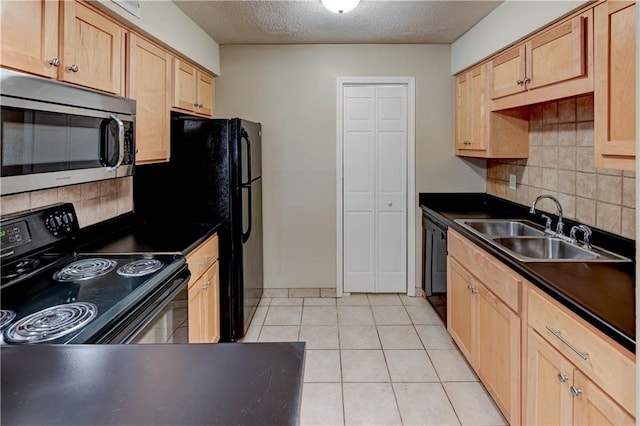 4157 Roanoke Rd Unit 2, Kansas City, MO 64111 - kitchen featuring black appliances, light brown cabinets, dark countertops, a sink, and a textured ceiling