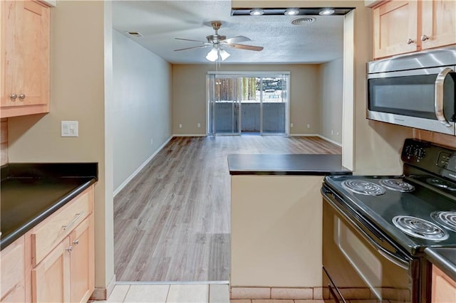 4157 Roanoke Rd Unit 2, Kansas City, MO 64111 - kitchen featuring black range with electric stovetop, stainless steel microwave, dark countertops, ceiling fan, and a textured ceiling