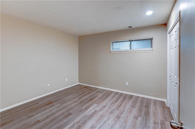 4157 Roanoke Rd Unit 2, Kansas City, MO 64111 - unfurnished bedroom featuring light wood finished floors, a textured ceiling, baseboards, and a closet