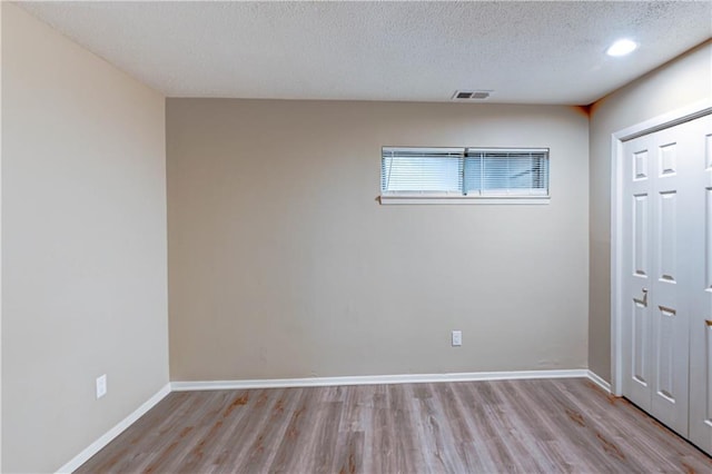 4157 Roanoke Rd Unit 2, Kansas City, MO 64111 - unfurnished bedroom featuring light wood-style flooring, a closet, a textured ceiling, and baseboards