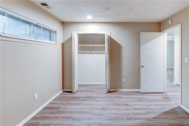 4157 Roanoke Rd Unit 2, Kansas City, MO 64111 - unfurnished bedroom featuring wood finished floors, a closet, a textured ceiling, and baseboards