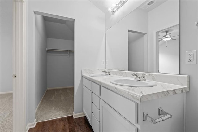 551 W Fountain St, Gardner, KS 66030 - bathroom featuring double vanity, baseboards, a ceiling fan, and a walk in closet
