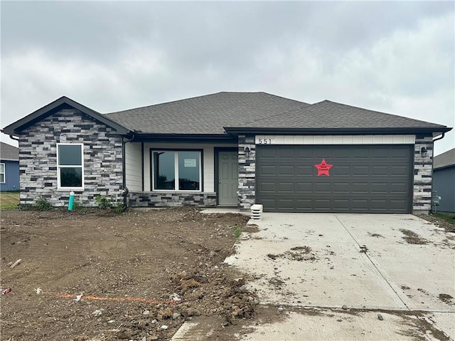 551 W Fountain St, Gardner, KS 66030 - view of front of house featuring stone siding, an attached garage, concrete driveway, and a shingled roof