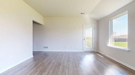 567 W Fountain St, Gardner, KS 66030 - empty room featuring wood finished floors, baseboards, and vaulted ceiling
