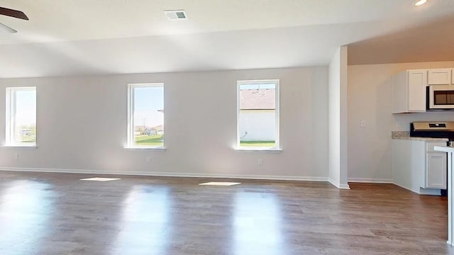 567 W Fountain St, Gardner, KS 66030 - unfurnished living room featuring healthy amount of natural light, wood finished floors, and baseboards