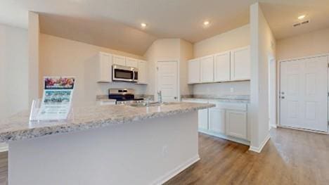 567 W Fountain St, Gardner, KS 66030 - kitchen featuring stainless steel microwave, range, dark wood-type flooring, white cabinets, and recessed lighting