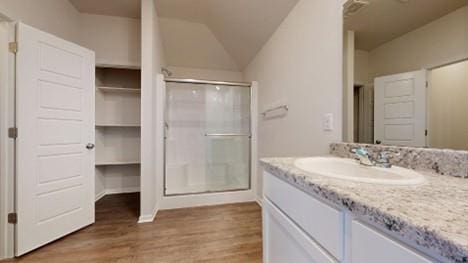 567 W Fountain St, Gardner, KS 66030 - full bath featuring a stall shower, vanity, wood finished floors, vaulted ceiling, and baseboards