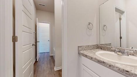 567 W Fountain St, Gardner, KS 66030 - bathroom featuring vanity, wood finished floors, and baseboards