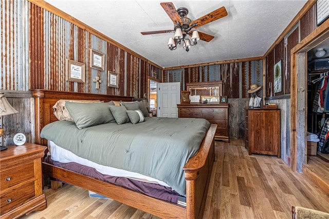 31425 Chance Ave, Warsaw, MO 65355 - bedroom featuring crown molding, hardwood / wood-style flooring, wood walls, and a textured ceiling