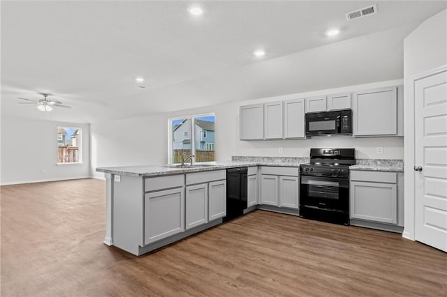 597 W Fountain St, Gardner, KS 66030 - kitchen featuring black appliances, gray cabinets, a sink, a peninsula, and light wood-style flooring