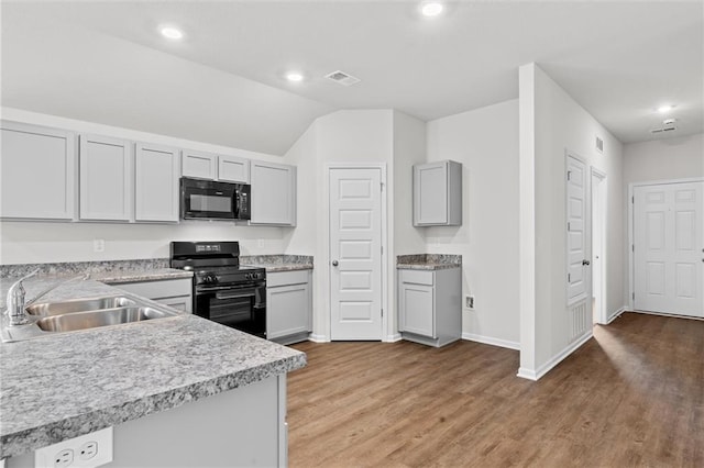 597 W Fountain St, Gardner, KS 66030 - kitchen with black appliances, a sink, light countertops, light wood-style floors, and recessed lighting