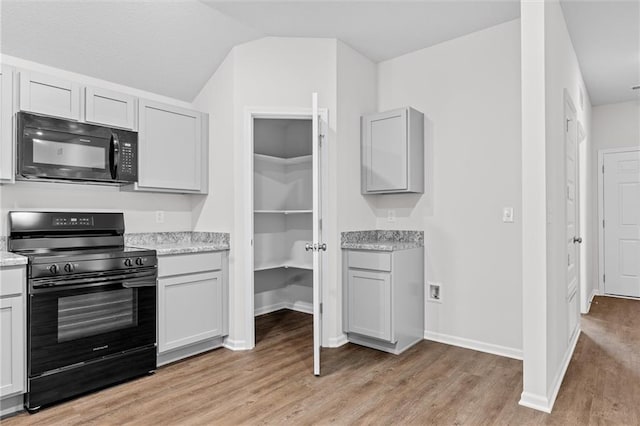 597 W Fountain St, Gardner, KS 66030 - kitchen featuring black appliances, light wood-style flooring, lofted ceiling, baseboards, and gray cabinets