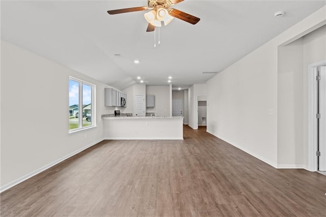 597 W Fountain St, Gardner, KS 66030 - unfurnished living room featuring wood finished floors, a ceiling fan, baseboards, vaulted ceiling, and recessed lighting