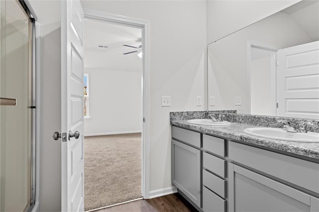 597 W Fountain St, Gardner, KS 66030 - full bathroom with double vanity, a stall shower, a ceiling fan, baseboards, and wood finished floors