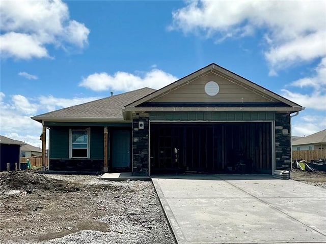 597 W Fountain St, Gardner, KS 66030 - view of front of home featuring an attached garage, driveway, and stone siding