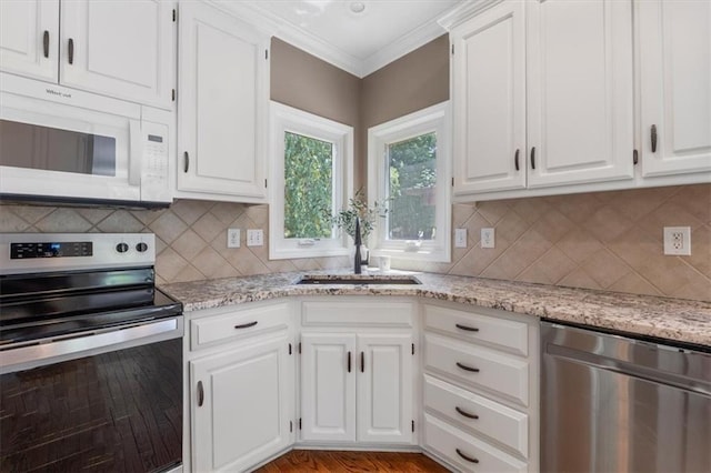 14155 W 147th Ter, Olathe, KS 66062 - kitchen with appliances with stainless steel finishes, backsplash, white cabinets, crown molding, and light stone countertops