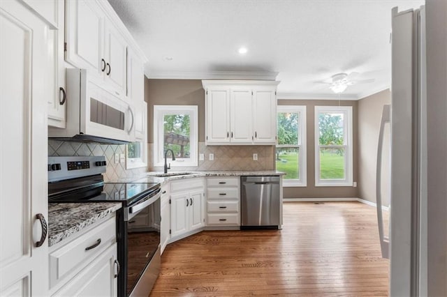 14155 W 147th Ter, Olathe, KS 66062 - kitchen featuring stainless steel appliances, a sink, crown molding, wood finished floors, and healthy amount of natural light