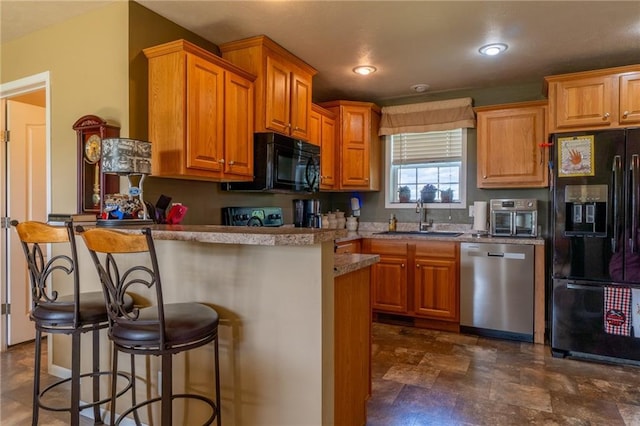2943 NE Turkey Rd, Breckenridge, MO 64625 - kitchen featuring black appliances, a sink, a kitchen breakfast bar, brown cabinets, and recessed lighting