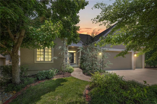16017 Kessler St, Overland Park, KS 66085 - view of front facade with concrete driveway, stucco siding, an attached garage, and a front yard