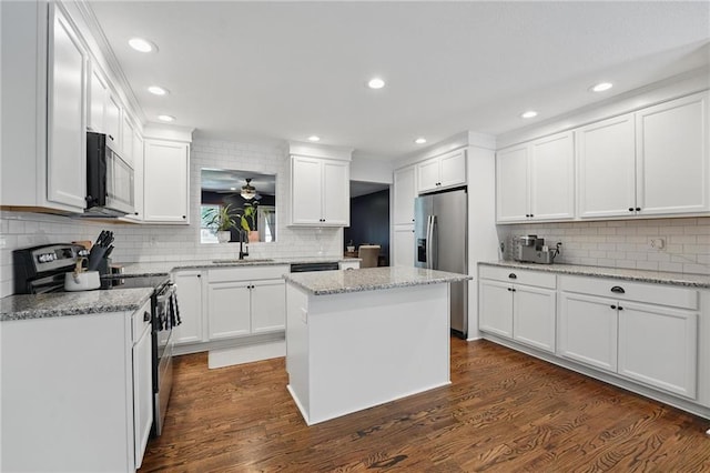 109 N 1st St, Blue Springs, MO 64014 - kitchen with appliances with stainless steel finishes, decorative backsplash, white cabinetry, a sink, and recessed lighting