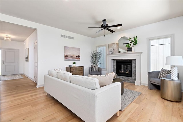 20786 Emerald St, Spring Hill, KS 66083 - living area featuring light wood finished floors, a glass covered fireplace, a ceiling fan, and baseboards