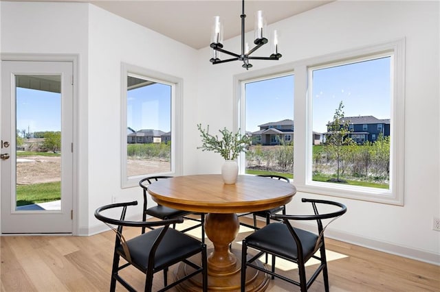 20786 Emerald St, Spring Hill, KS 66083 - dining area featuring a chandelier, light wood-type flooring, baseboards, and a residential view