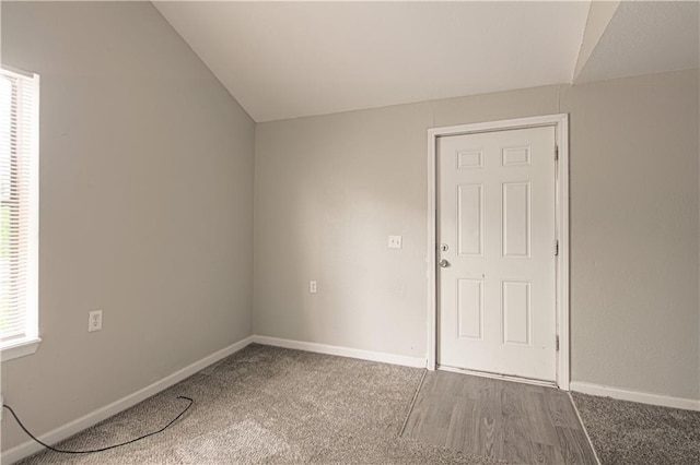 5926 Agnes Ave, Kansas City, MO 64130 - empty room featuring vaulted ceiling, baseboards, plenty of natural light, and carpet flooring