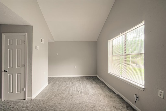 5926 Agnes Ave, Kansas City, MO 64130 - additional living space featuring vaulted ceiling, carpet floors, baseboards, and wood finished floors