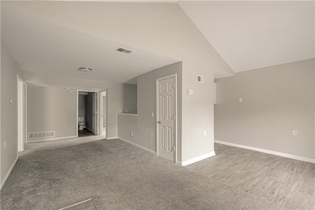 5926 Agnes Ave, Kansas City, MO 64130 - carpeted empty room with baseboards and vaulted ceiling