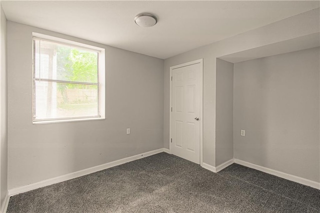 5926 Agnes Ave, Kansas City, MO 64130 - unfurnished bedroom with dark carpet and baseboards