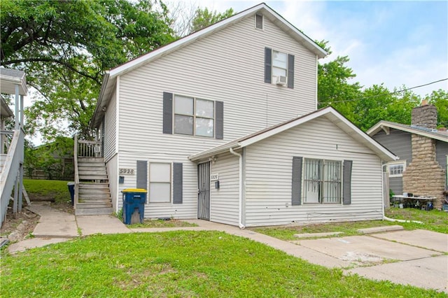 5926 Agnes Ave, Kansas City, MO 64130 - view of front of house with stairs, a front yard, and a deck