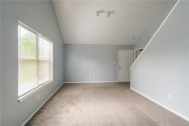 5926 Agnes Ave, Kansas City, MO 64130 - unfurnished living room with vaulted ceiling, carpet floors, and baseboards