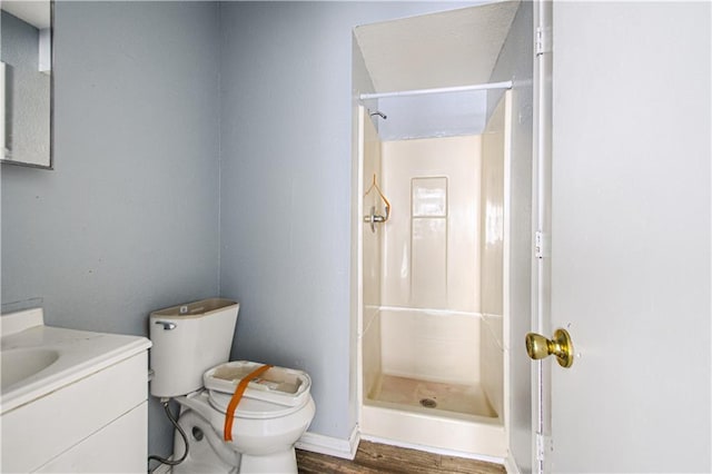 5926 Agnes Ave, Kansas City, MO 64130 - full bathroom featuring toilet, a stall shower, vanity, wood finished floors, and baseboards