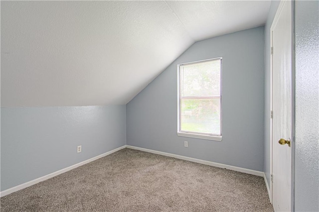 5926 Agnes Ave, Kansas City, MO 64130 - additional living space featuring vaulted ceiling, carpet flooring, a textured ceiling, and baseboards
