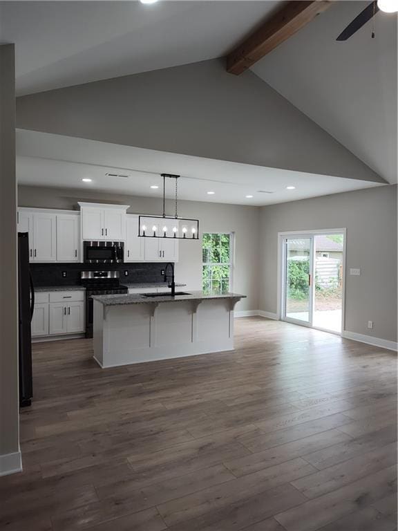802 E N Main St, Richmond, MO 64085 - kitchen with black appliances, open floor plan, beamed ceiling, a center island with sink, and white cabinetry