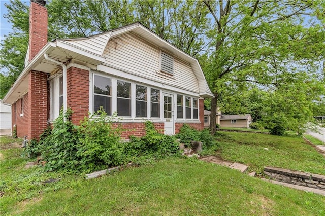 1403 S Sterling Ave, Independence, MO 64052 - view of side of home featuring brick siding, a chimney, and a yard