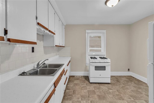 1403 S Sterling Ave, Independence, MO 64052 - kitchen featuring white range with gas stovetop, a sink, light countertops, tasteful backsplash, and baseboards