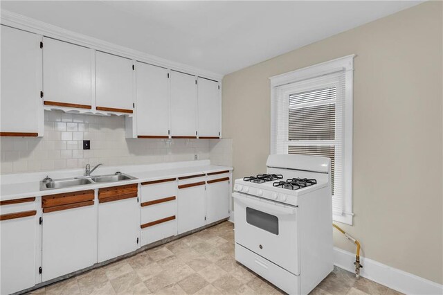 1403 S Sterling Ave, Independence, MO 64052 - kitchen with white range with gas cooktop, a sink, decorative backsplash, light countertops, and white cabinetry