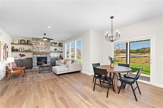 20714 Emerald St, Spring Hill, KS 66030 - dining space with light wood-style flooring, a chandelier, ceiling fan, a fireplace, and recessed lighting