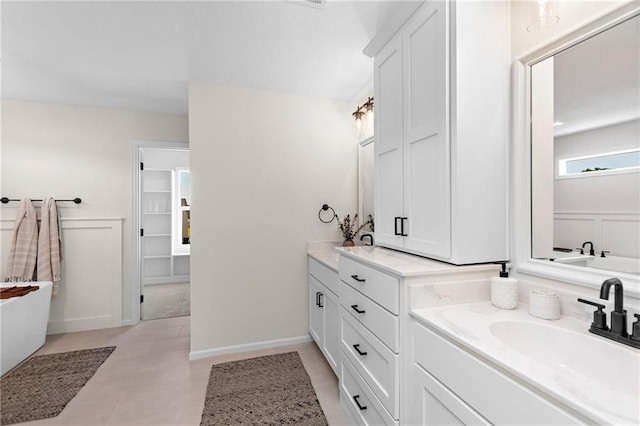 20714 Emerald St, Spring Hill, KS 66030 - bathroom featuring vanity, a wainscoted wall, a decorative wall, a bathtub, and a closet