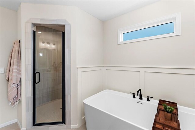 20714 Emerald St, Spring Hill, KS 66030 - full bathroom with a freestanding bath, a shower stall, a decorative wall, and wainscoting