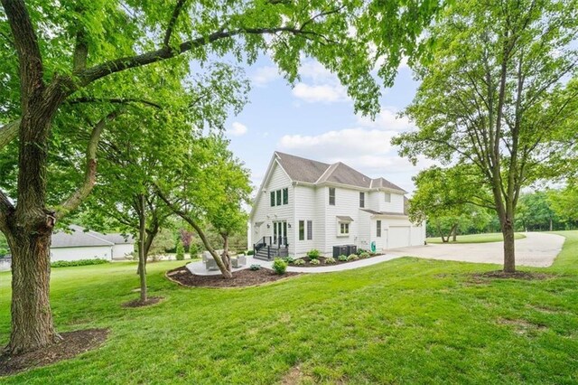 7007 Bell Rd, Shawnee, KS 66217 - view of front facade with driveway, a garage, a front lawn, and cooling unit